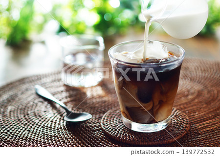 Summer iced café au lait - pour milk into iced coffee Summer iced café au lait - pour milk into iced coffee 139772532