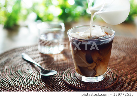 Summer iced café au lait - pour milk into iced coffee Summer iced café au lait - pour milk into iced coffee 139772533