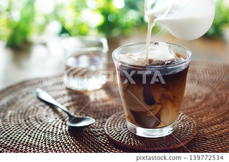 Summer iced café au lait - pour milk into iced coffee Summer iced café au lait - pour milk into iced coffee 139772534