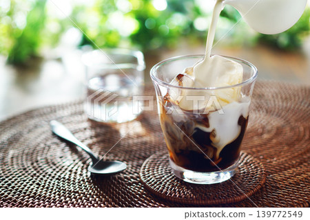 Summer iced café au lait - pour milk into iced coffee Summer iced café au lait - pour milk into iced coffee 139772549