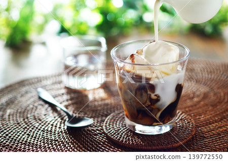 Summer iced café au lait - pour milk into iced coffee Summer iced café au lait - pour milk into iced coffee 139772550