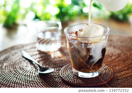 Summer iced café au lait - pour milk into iced coffee Summer iced café au lait - pour milk into iced coffee 139772552