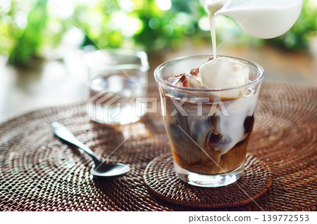 Summer iced café au lait - pour milk into iced coffee Summer iced café au lait - pour milk into iced coffee 139772553