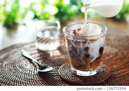Summer iced café au lait - pour milk into iced coffee Summer iced café au lait - pour milk into iced coffee 139772554