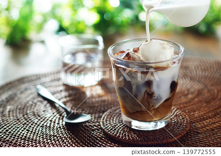 Summer iced café au lait - pour milk into iced coffee Summer iced café au lait - pour milk into iced coffee 139772555