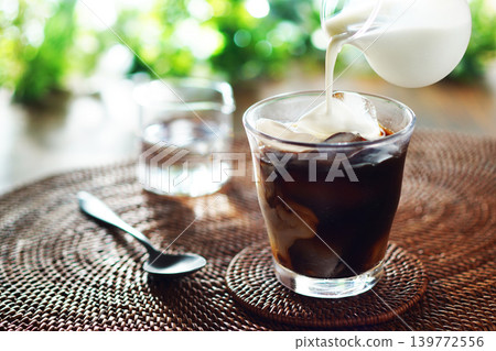 Summer iced café au lait - pour milk into iced coffee Summer iced café au lait - pour milk into iced coffee 139772556