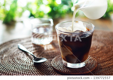 Summer iced café au lait - pour milk into iced coffee Summer iced café au lait - pour milk into iced coffee 139772557