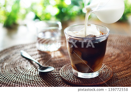 Summer iced café au lait - pour milk into iced coffee Summer iced café au lait - pour milk into iced coffee 139772558