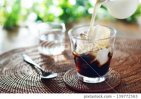 Summer iced café au lait - pour milk into iced coffee Summer iced café au lait - pour milk into iced coffee 139772563