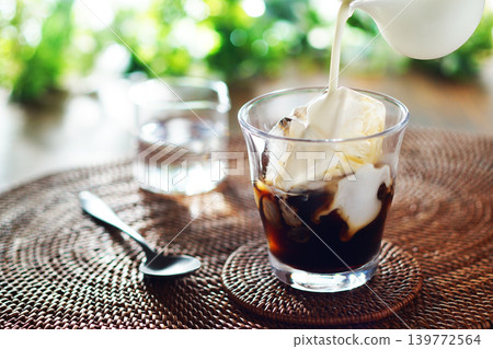 Summer iced café au lait - pour milk into iced coffee Summer iced café au lait - pour milk into iced coffee 139772564