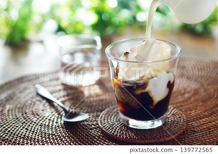 Summer iced café au lait - pour milk into iced coffee Summer iced café au lait - pour milk into iced coffee 139772565