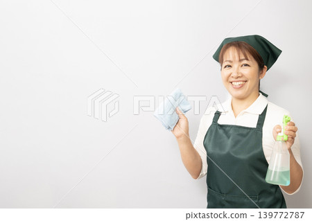 一位清潔女工拿著洗滌劑和毛巾 一位清潔女工拿著洗滌劑和毛巾 139772787