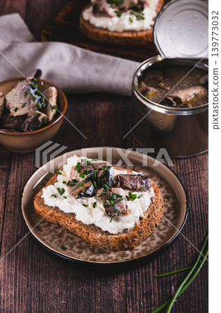 Open sandwiches with ricotta, sardines and chives on a plate on the table vertical view 139773032
