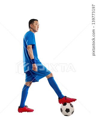 A young Indonesian southeast asian male athlete in a full blue soccer kit stands confidently with one foot resting on a soccer ball, isolated against a white background A young Indonesian southeast asian male athlete in a full blue soccer kit stands confidently with one foot resting on a soccer ball, isolated against a white background 139773197