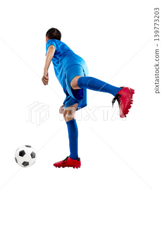 Full length portrait of a young Indonesian southeast asian man in a blue uniform kicking a soccer ball, isolated against a white background Full length portrait of a young Indonesian southeast asian man in a blue uniform kicking a soccer ball, isolated against a white background 139773203