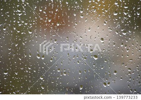 Raindrops on a window create a beautiful, blurred background Raindrops on a window create a beautiful, blurred background 139773233