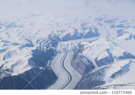 從高空俯瞰，可以看到北極和格陵蘭島白雪皚皚的山峰和蜿蜒流淌在山谷中的河流。 139773466