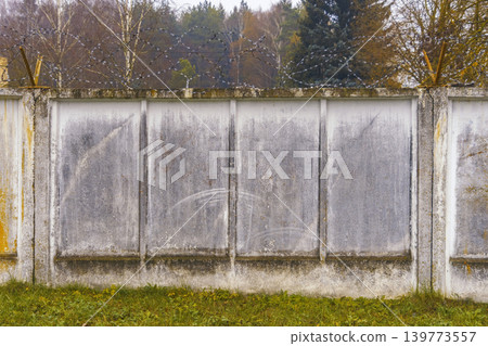 Rugged fence scenery. Industrial fencing featuring textured surfaces and natural ecological elements Rugged fence scenery. Industrial fencing featuring textured surfaces and natural ecological elements 139773557