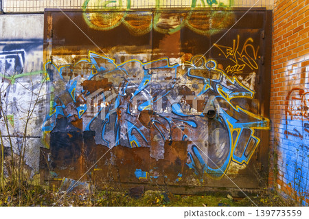 Bright graffiti on old bricks. Energetic street art contrasts with neglected urban decay and nature Bright graffiti on old bricks. Energetic street art contrasts with neglected urban decay and nature 139773559
