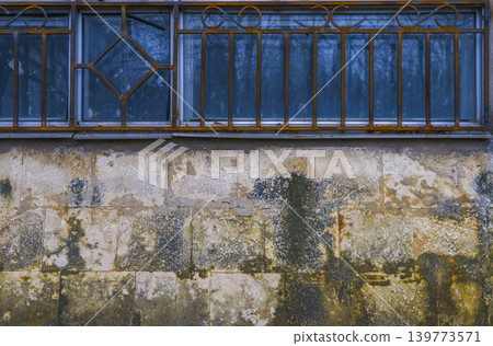 Ornamented metal balustrade mounted on weathered stone wall with heritage industrial ambiance Ornamented metal balustrade mounted on weathered stone wall with heritage industrial ambiance 139773571