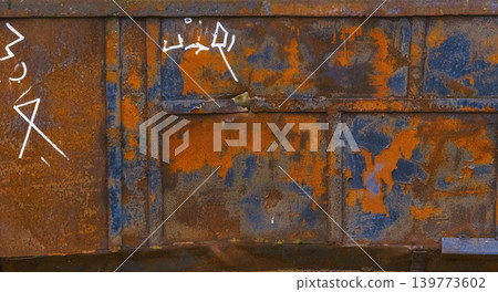 Corroded steel door with graffiti. Rusty metal panel showing peeling paint and rough texture Corroded steel door with graffiti. Rusty metal panel showing peeling paint and rough texture 139773602