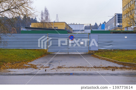 Quiet industrial area with fallen leaves. Corrugated front facing sidewalk covered in autumn leaves Quiet industrial area with fallen leaves. Corrugated front facing sidewalk covered in autumn leaves 139773614
