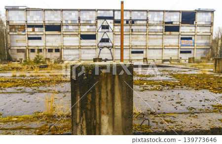 An individual standing alone on concrete structure amid abandoned surroundings and gloomy atmosphere An individual standing alone on concrete structure amid abandoned surroundings and gloomy atmosphere 139773646