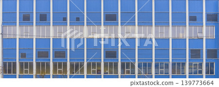 Urban structures feature uniform windows. Cityscape shows mirrored glass with minimal color Urban structures feature uniform windows. Cityscape shows mirrored glass with minimal color 139773664