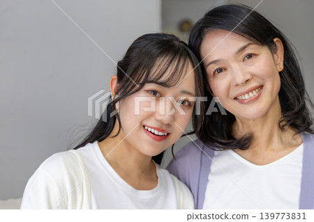 A close mother and daughter leaning their faces together 139773831