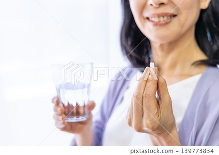 老婦人在窗邊吃藥 139773834