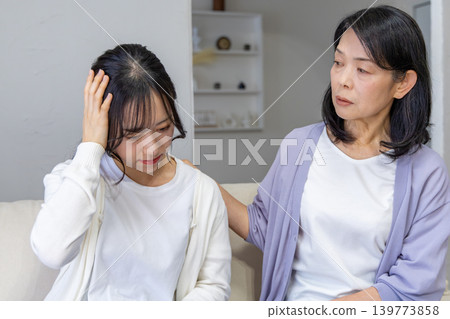 Daughter holding her head, mother worried. Daughter holding her head, mother worried. 139773858