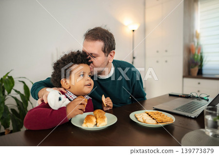 Father kissing son while having breakfast at home Father kissing son while having breakfast at home 139773879