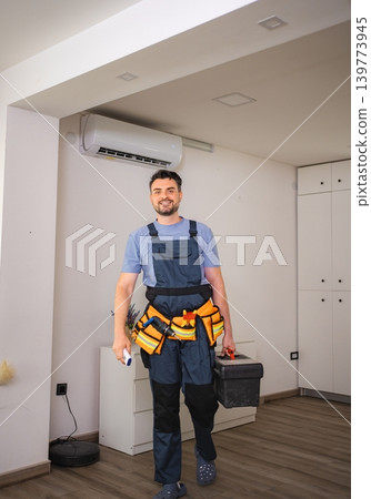 Technician walking and holding toolbox and remote control for air conditioning Technician walking and holding toolbox and remote control for air conditioning 139773945