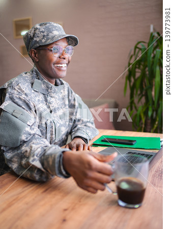 Happy military woman taking a coffee break while working from home Happy military woman taking a coffee break while working from home 139773981