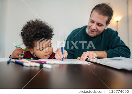 Father and son drawing together using markers at home Father and son drawing together using markers at home 139774000