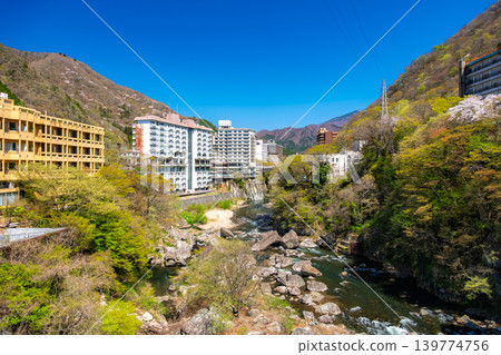 栃木縣日光市:在湛藍的天空下,綠樹環繞,鬼怒川溫泉美麗的山谷景色和飯店建築群。 栃木縣日光市:在湛藍的天空下,綠樹環繞,鬼怒川溫泉美麗的山谷景色和飯店建築群。 139774756