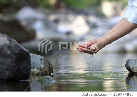 Holding clear, transparent valley water in your hands, the clean water of life given by beautiful nature, World Water Day backdrop Holding clear, transparent valley water in your hands, the clean water of life given by beautiful nature, World Water Day backdrop 139774933