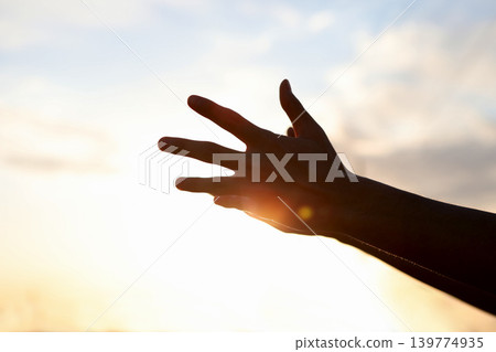 A symbolic background expressing a hopeful heart and spiritual faith at the moment of reaching out both hands toward the sky to earnestly hope and pray. A symbolic background expressing a hopeful heart and spiritual faith at the moment of reaching out both hands toward the sky to earnestly hope and pray. 139774935