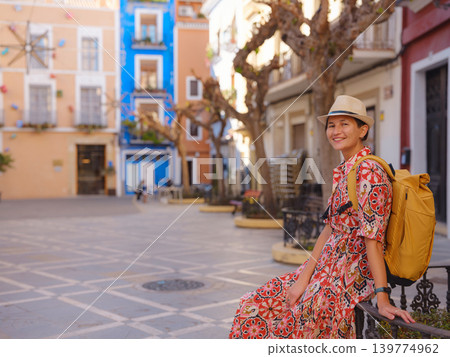 Woman strolls through colorful streets of Spanish coastal town Woman strolls through colorful streets of Spanish coastal town 139774962