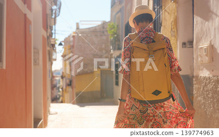 Woman strolls through colorful streets of Spanish coastal town Woman strolls through colorful streets of Spanish coastal town 139774963