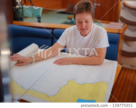 Woman Sailor Studying Navigation Map Inside Yacht Cabin Interior Woman Sailor Studying Navigation Map Inside Yacht Cabin Interior 139775051