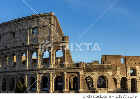 Famous Coliseum in Rome. Colosseum, or Coliseum. Sunset at huge Roman amphitheatre, Rome, Italy, Europe. Famous touristic place in the world and Europe. Beautiful blue sky background. Famous Coliseum in Rome. Colosseum, or Coliseum. Sunset at huge Roman amphitheatre, Rome, Italy, Europe. Famous touristic place in the world and Europe. Beautiful blue sky background. 139775179