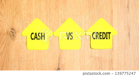 Cash vs credit words symbol. Concept words Cash vs credit on beautiful yellow paper houses. Beautiful wooden background. Business and cash vs credit concept. Copy space. 139775247