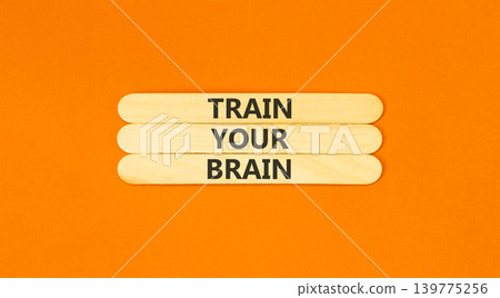 Train your brain words symbol. Concept words Train your brain on beautiful wooden sticks. Beautiful orange background. Business motivational and train your brain concept. Copy space. 139775256