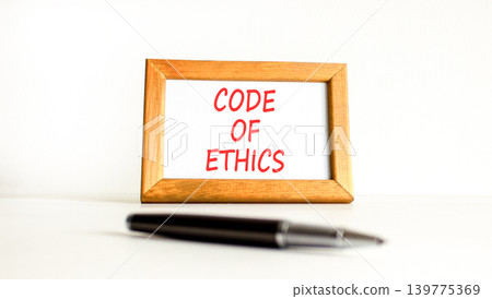 Code of ethics words symbol. Concept words Code of ethics on beautiful wooden picture frame. Beautiful white background. Business Code of ethics concept. Copy space. Code of ethics words symbol. Concept words Code of ethics on beautiful wooden picture frame. Beautiful white background. Business Code of ethics concept. Copy space. 139775369