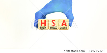 HSA health saving account symbol. Concept words HSA health saving account on beautiful wooden blocks. Beautiful white background. Doctor hand. Medical HSA health saving account concept. Copy space. HSA health saving account symbol. Concept words HSA health saving account on beautiful wooden blocks. Beautiful white background. Doctor hand. Medical HSA health saving account concept. Copy space. 139775429
