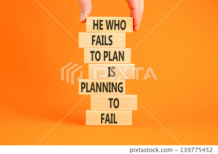 Planning to fail symbol. Concept words He who fails to plan is planning to fail on beautiful wooden blocks. Beautiful orange background. Businessman hand. Business planning to fail concept. Copy space 139775452