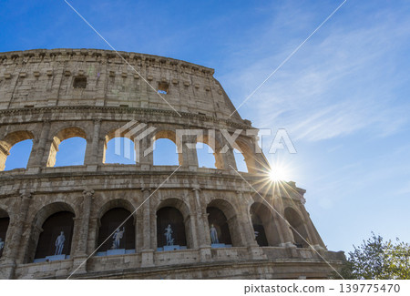 Famous Coliseum in Rome. Colosseum, or Coliseum. Sunset at huge Roman amphitheatre, Rome, Italy, Europe. Famous touristic place in the world and Europe. Beautiful blue sky background. Famous Coliseum in Rome. Colosseum, or Coliseum. Sunset at huge Roman amphitheatre, Rome, Italy, Europe. Famous touristic place in the world and Europe. Beautiful blue sky background. 139775470