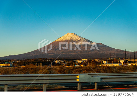 A Japanese landscape: Mount Fuji illuminated by the setting sun, as seen from a highway. A Japanese landscape: Mount Fuji illuminated by the setting sun, as seen from a highway. 139775564