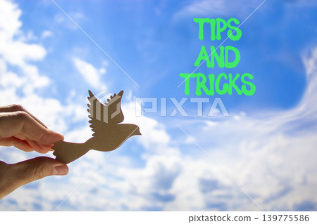 Tips and tricks words symbol. Concept words Tips and tricks on beautiful blue sky. Beautiful blue sky background. Businessman hand. Business tips and tricks motivational support concept. Copy space. Tips and tricks words symbol. Concept words Tips and tricks on beautiful blue sky. Beautiful blue sky background. Businessman hand. Business tips and tricks motivational support concept. Copy space. 139775586